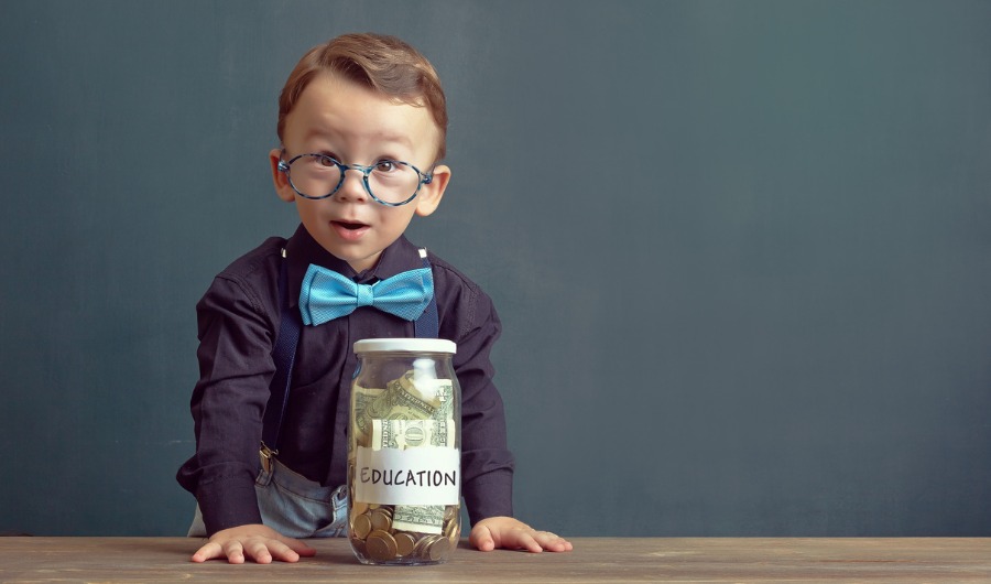 בתמונה ילד מחזיק קופת חסכון מלאה בכסף מתויגת עם מדבקת "לימודים" כיתוב: "תנו שם לחיסכון – ככה הסיכויים למימוש גדל"