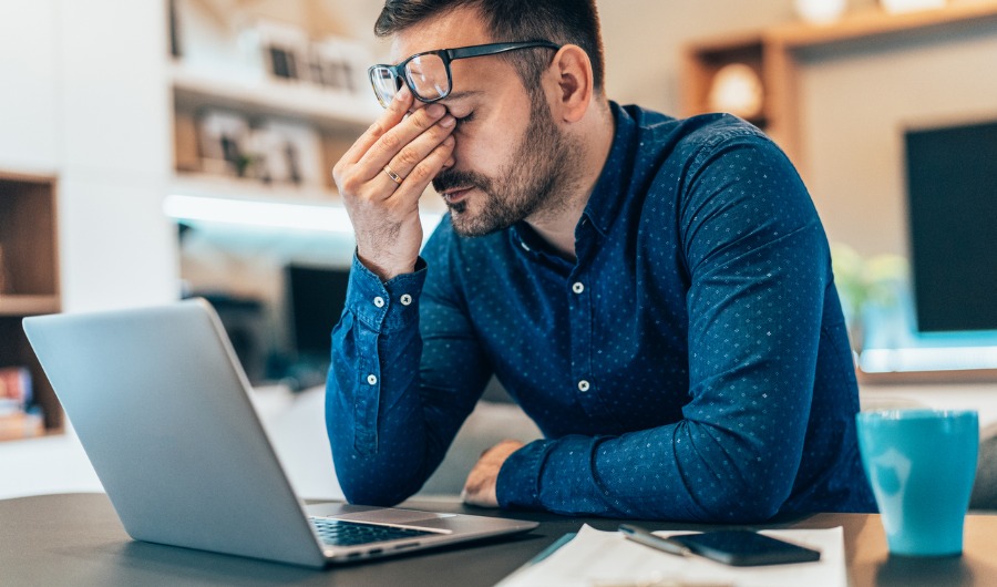 בחור יושב מול מחשב ומשפשף את העיניים מעייפות